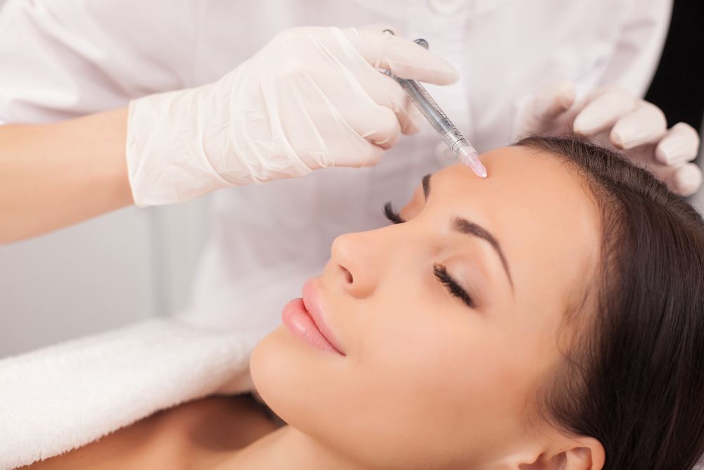Beautiful woman closes her eyes and relaxes during preventative Botox injections at her medspa
